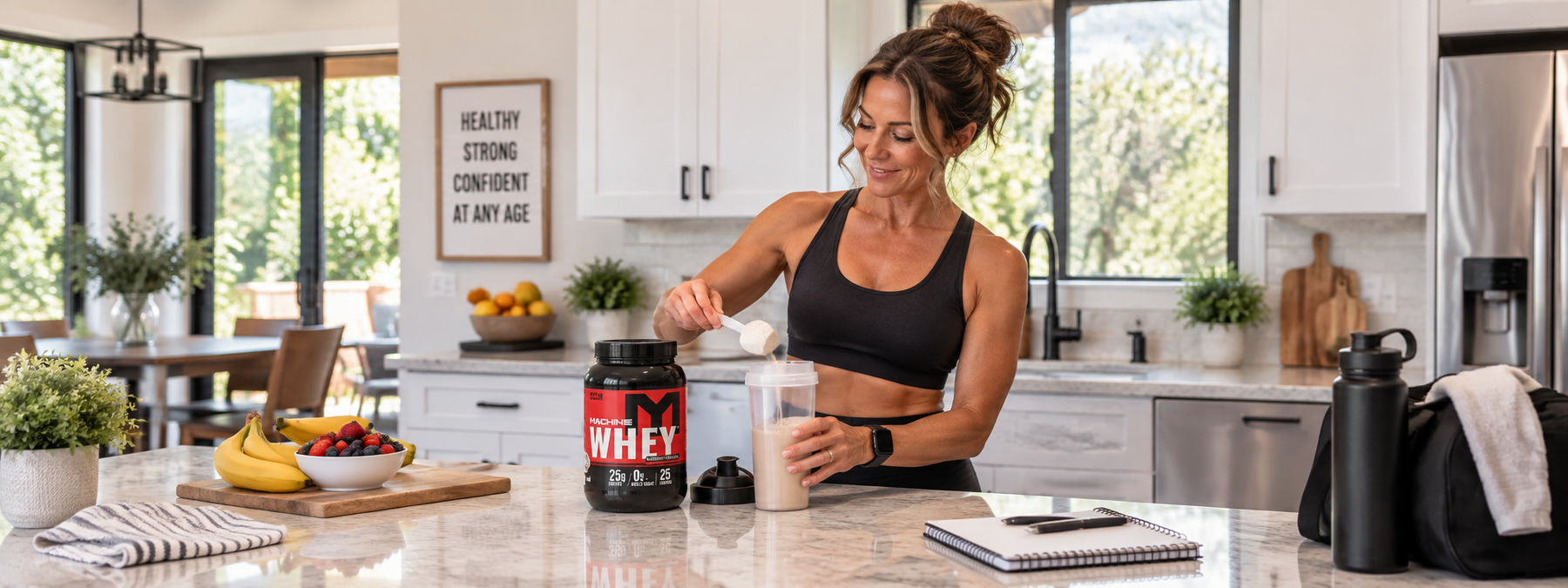 Fit woman over 40 preparing a protein shake with Machine Whey protein powder in a bright home kitchen.