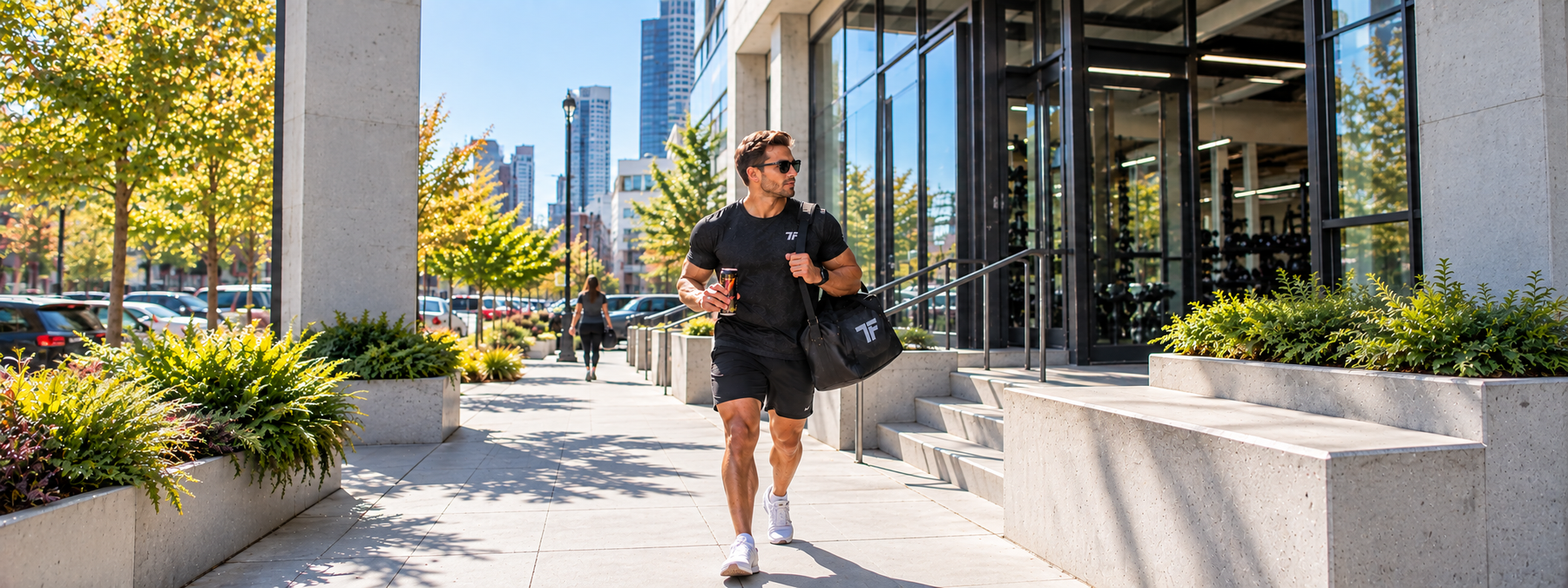Fit man heading to the gym with an energy drink and gym bag for an afternoon workout.
