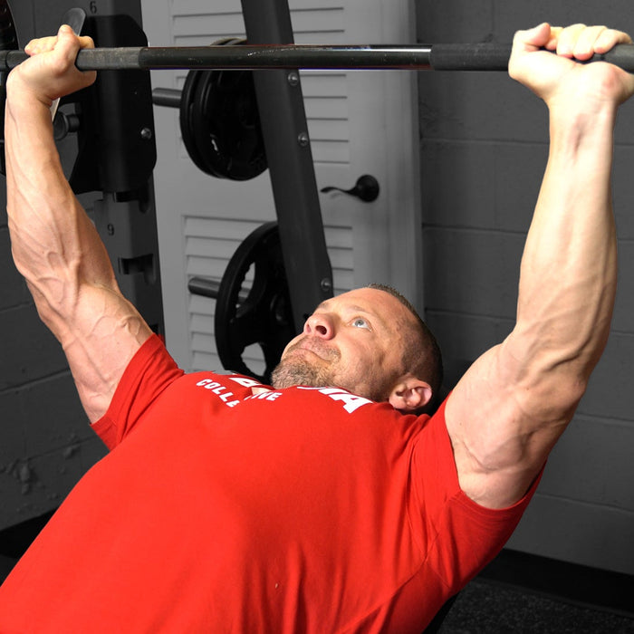 Athlete performing a barbell bench press for chest development