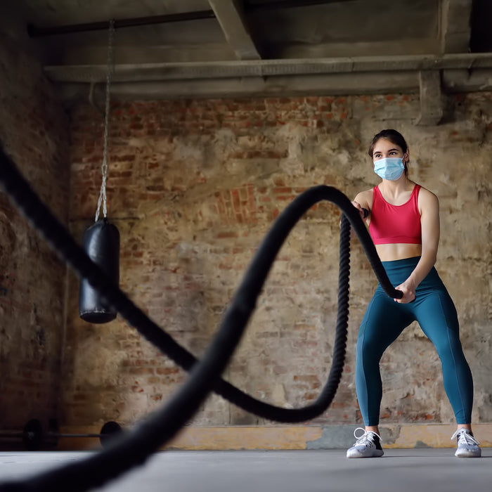 Woman wearing a face mask while exercising post pandemic
