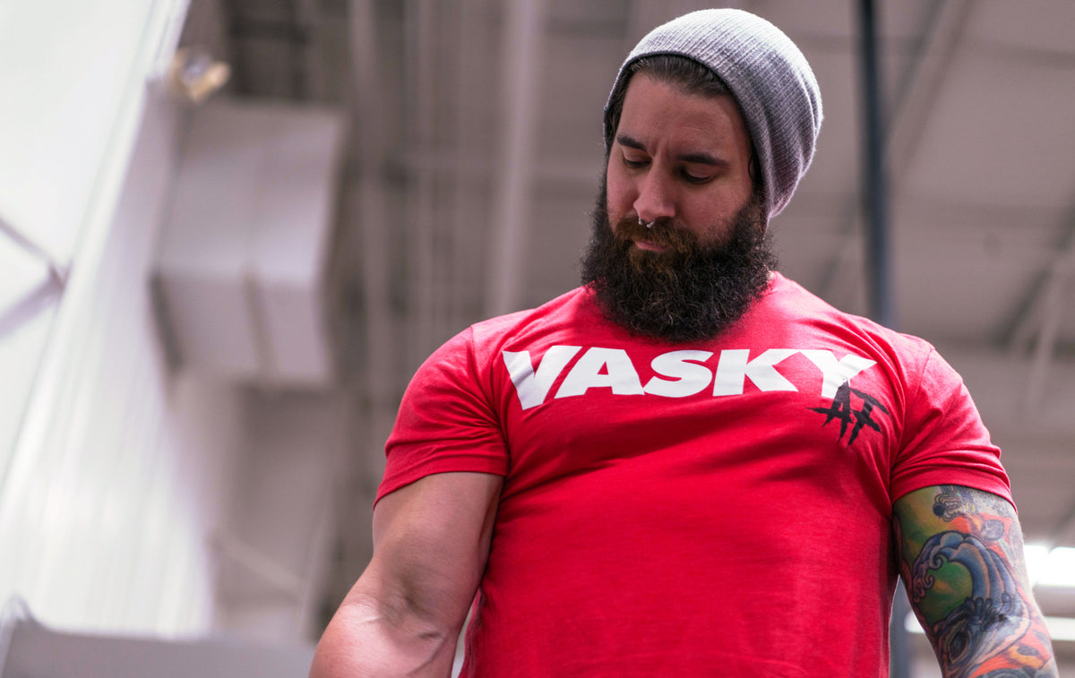 An athlete pressing a kettlebell overhead midway through a Turkish get up, core braced and eyes locked on the bell.