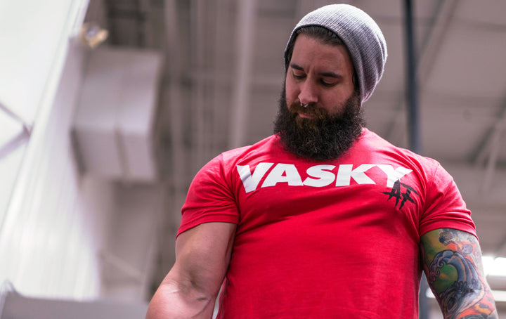 An athlete pressing a kettlebell overhead midway through a Turkish get up, core braced and eyes locked on the bell.