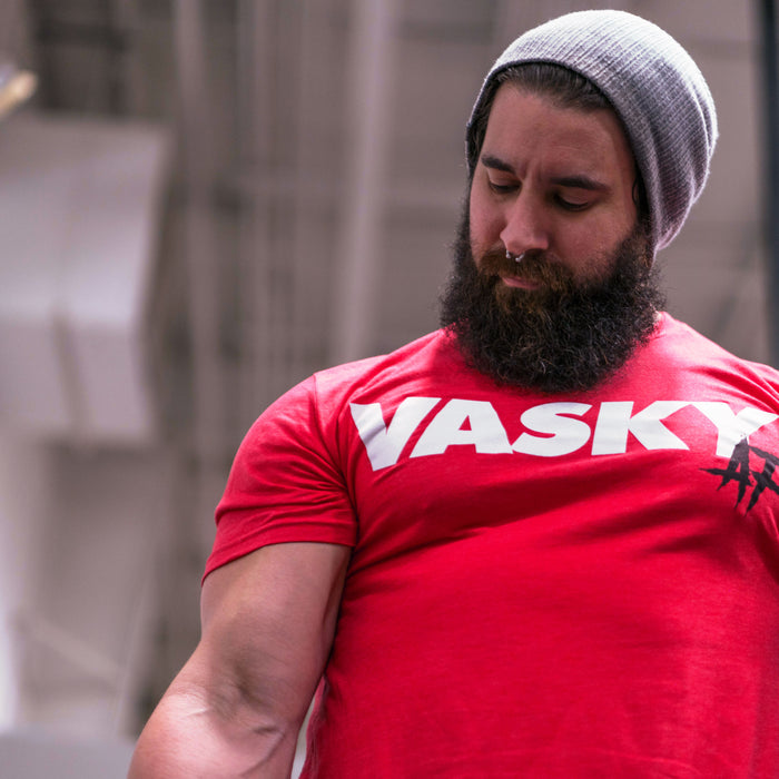 An athlete pressing a kettlebell overhead midway through a Turkish get up, core braced and eyes locked on the bell.