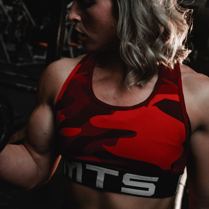 Female athlete Ireland Beatty performing a cable tricep pushdown in the gym, the kind of machine and cable work this Planet Fitness plan for women is built on