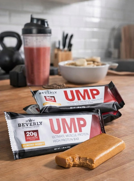 Beverly International UMP Protein Bar in Almond Honey flavor displayed with coffee and gym accessories.