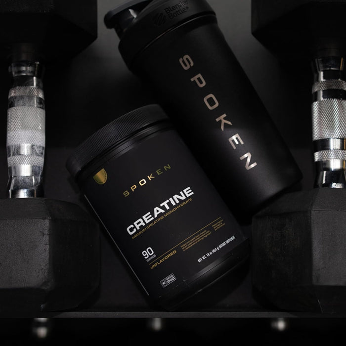 Spoken Nutrition Creatine powder displayed in gym environment – strength and muscle building supplement.