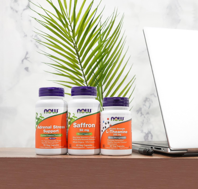 NOW Foods Adrenal Stress Support supplement bottles on desk with laptop and plant representing stress and cortisol support