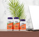 NOW Foods Adrenal Stress Support supplement bottles on desk with laptop and plant representing stress and cortisol support